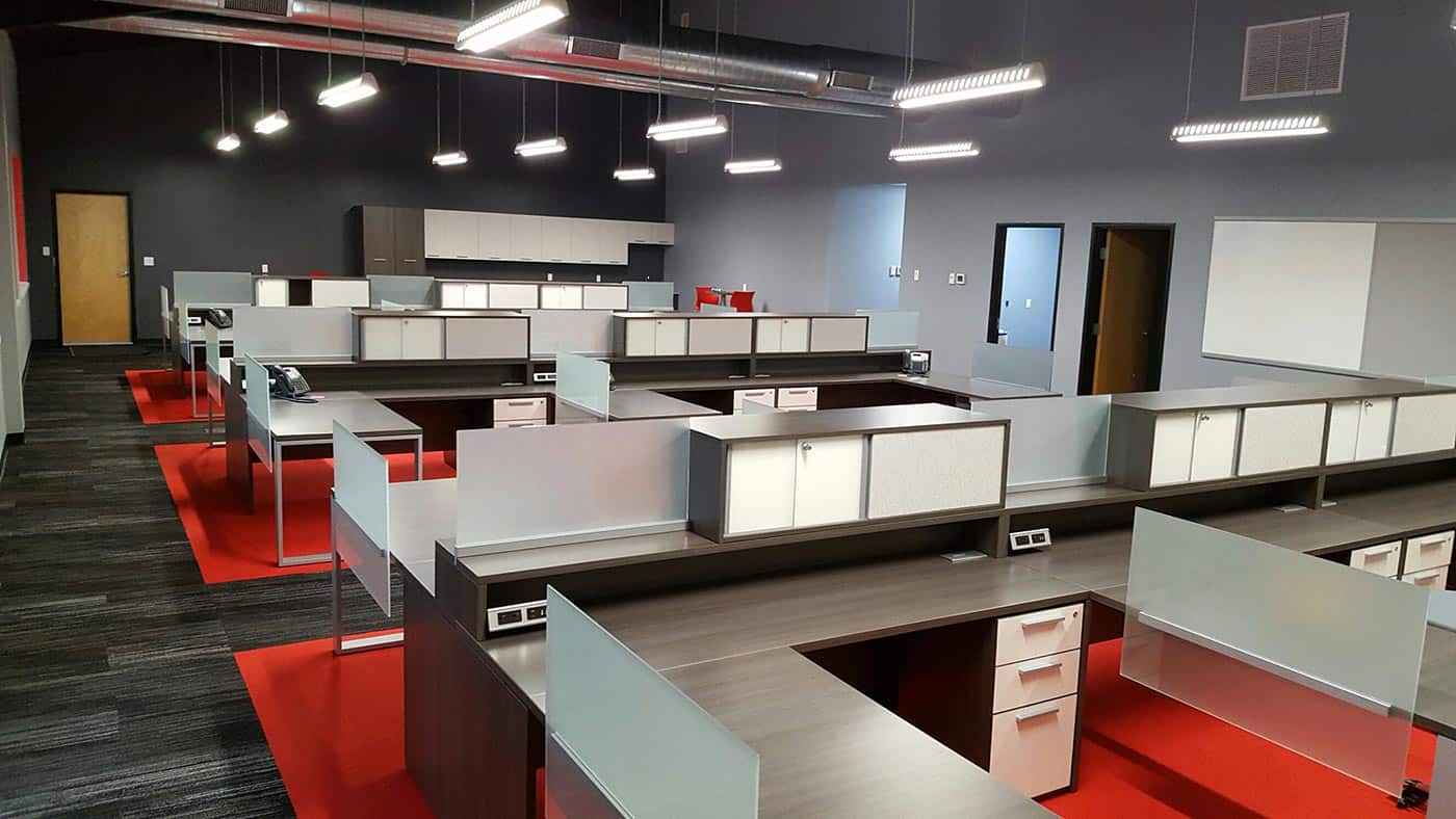 Modern open office desk layout, silver, red, dark wood colors. Sleek, minimal design and layout.