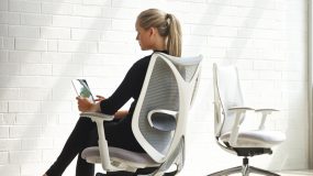 A woman sitting in a high-quality task chair that is comfortable and beautifully designed.