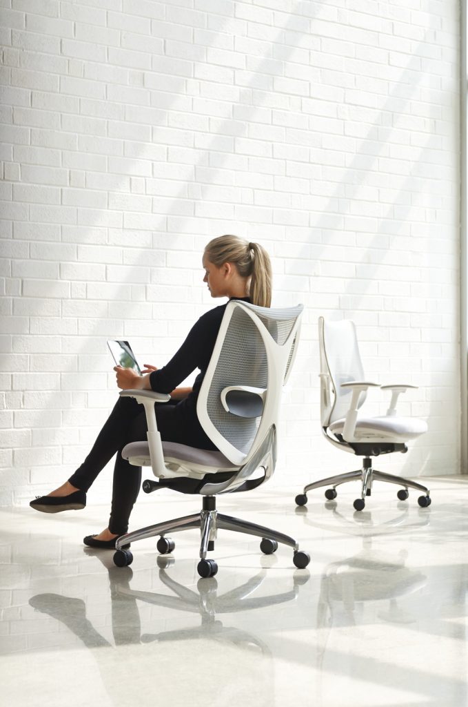A woman sitting in a high-quality task chair that is comfortable and beautifully designed.