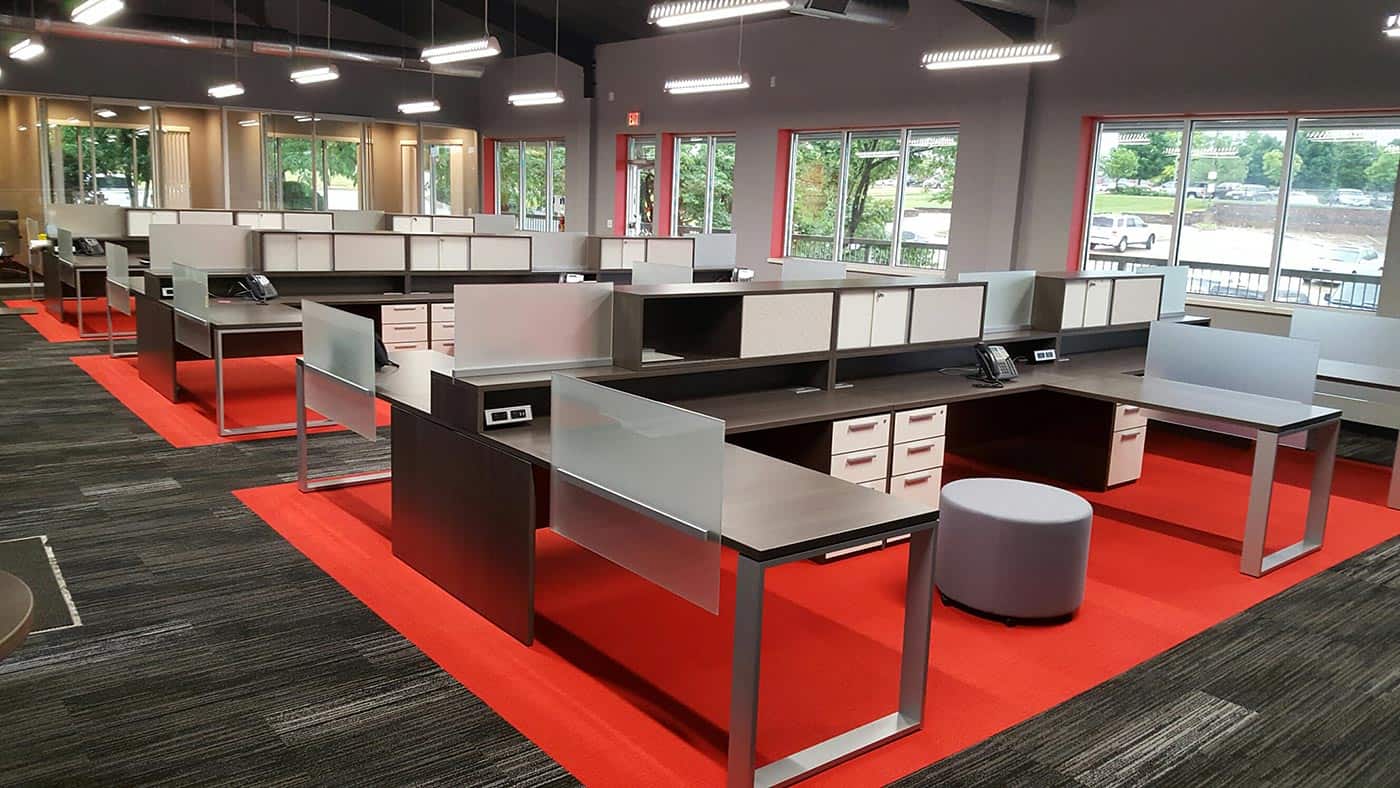 Modern open office desk layout, silver, red, dark wood colors. Sleek, minimal design and layout.