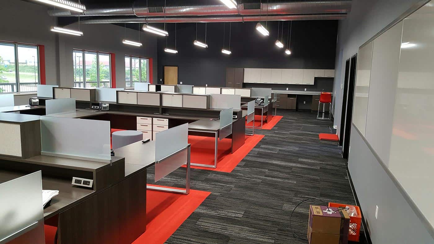 Modern open office desk layout, silver, red, dark wood colors. Sleek, minimal design and layout.
