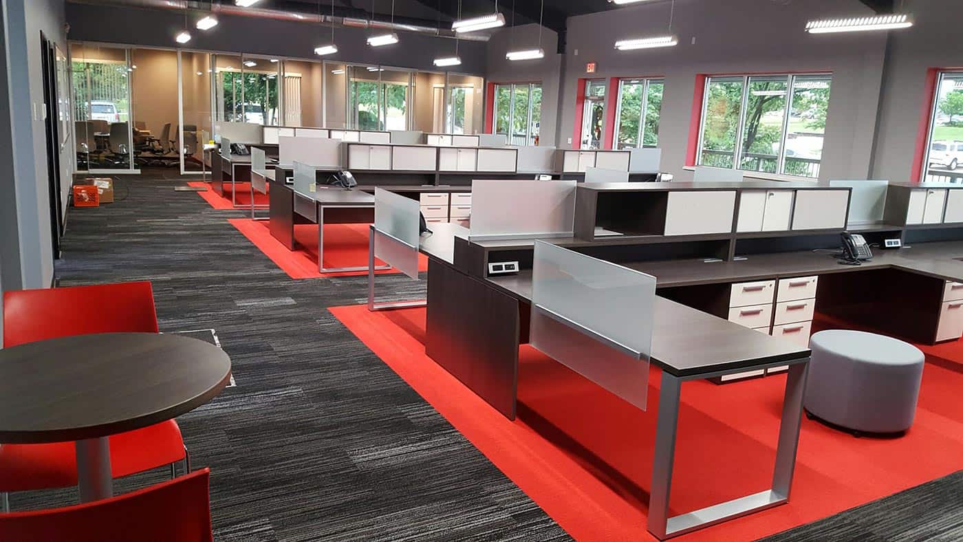 Modern open office desk layout, silver, red, dark wood colors. Sleek, minimal design and layout.